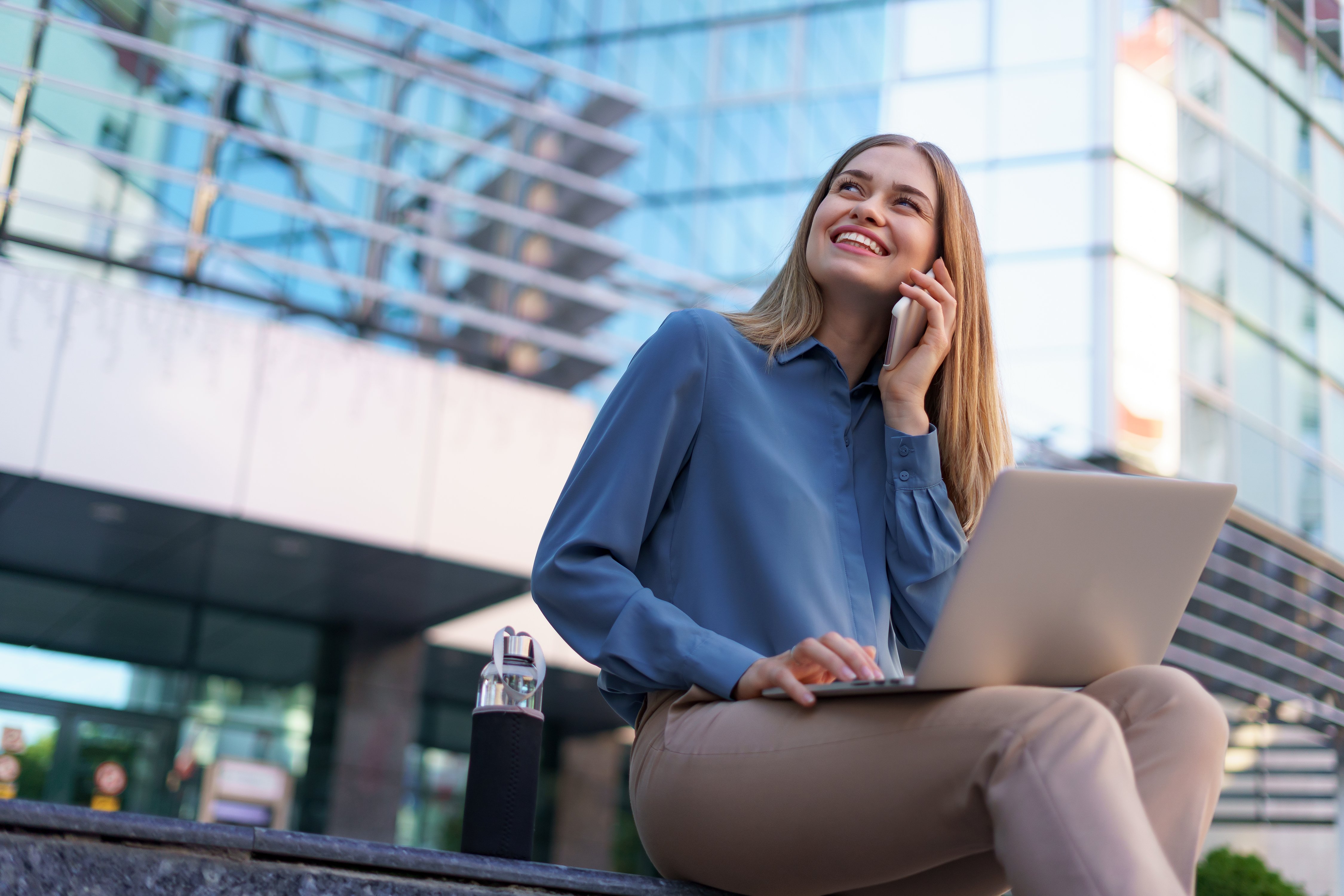 young-professional-woman-sitting-stair-front-glass-building-holding-laptop-lap-talking-mobile-phone young-professional-woman-sitting-stair-front-glass-building-holding-laptop-lap-talking-mobile-phone